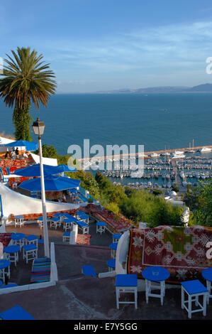 Un café avec un aspect panoramique composé de terrasses taillées dans la falaise au-dessus du port de plaisance de Sidi Bou Said Banque D'Images