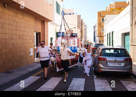 Regarder le défilé de chars décorés, des bateaux avec des participants habillés en blanc à la romeria barquero fiesta en El Medano, Banque D'Images