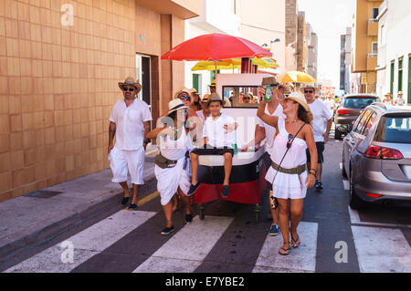 Regarder le défilé de chars décorés, des bateaux avec des participants habillés en blanc à la romeria barquero fiesta en El Medano, Banque D'Images