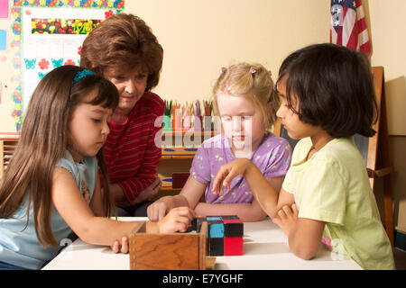 L'âge de 5-6 ans ans la diversité raciale ethnique multi multiculturelles la diversité raciale de la maternelle enseignant travail filles travailler ensemble POV Banque D'Images