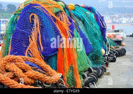 Filets de pêche colorés empilés sur le quai. Port de Lyme Regis, Dorset, Angleterre, Royaume-Uni Banque D'Images