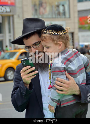 Un homme juif religieux et son neveu regarder des photos de Union Square Park à Manhattan, New York Banque D'Images