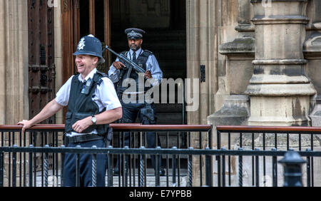 Deux policiers photographiés à l'extérieur de Londres le Palais de Westminster, sur Saint Margaret ST. La première, c'est détendu et souriant alors que Banque D'Images