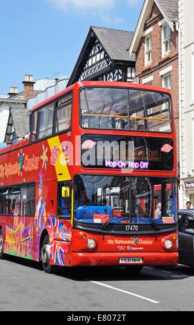 Vue frontale d'un open tour bus rouge surmonté le long Bridge Street, Chester, Cheshire, Angleterre, Royaume-Uni, Europe de l'Ouest. Banque D'Images