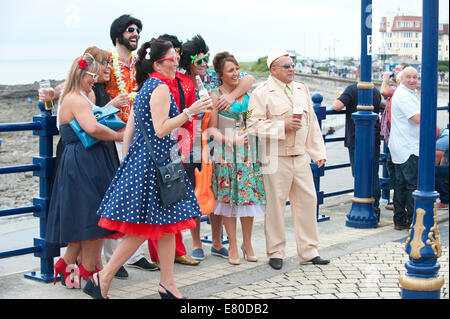 Porthcawl, Glamorgan, Pays de Galles, Royaume-Uni. 27 Septembre, 2014. L'usure des fans d'Elvis fancy dress. Des dizaines de milliers de fans d'Elvis Presley descendre sur la petite ville balnéaire de Porthcawl gallois dans le sud du Pays de Galles pour trois jours de célébration de toutes les choses Elvis et d'écouter Elvis Tribute artistes au plus grand festival du genre en Europe. Credit : Graham M. Lawrence/Alamy Live News. Banque D'Images