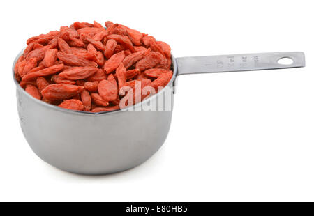 Baies de goji rouge dans une tasse mesurer, isolé sur fond blanc Banque D'Images