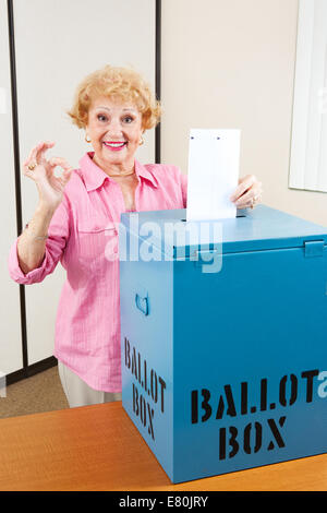 Senior woman dépose son bulletin dans la boîte et donne un bon signe. Banque D'Images