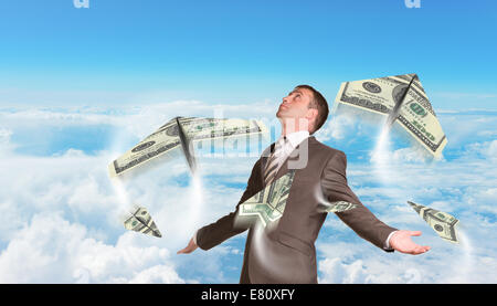 Businessman with avions en papier faite de centaines de dollar bills Banque D'Images