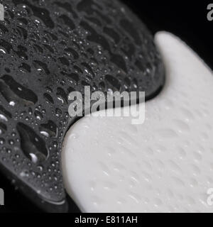 Yin-Yang symbole texture de pierre, le signe des deux éléments avec peu d'eau sur fond noir Banque D'Images