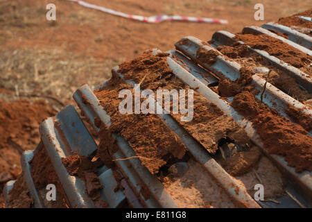 Une excavatrice caterpillar track couvert de caillots de boue, de saleté et de latérite. Banque D'Images