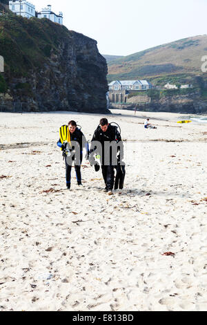 Deux plongeurs sous-équipement plongée réservoirs réservoir air combinaisons fonction respiratoire autonome à pied de la plage sur la mer divers Banque D'Images