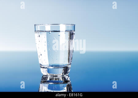 L'eau potable dans le verre sur bleu Banque D'Images