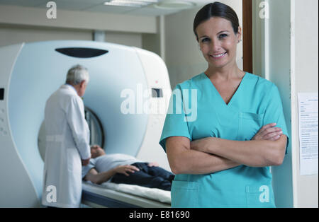 Happy young female doctor with man patient en arrière-plan en tomodensitométrie. Banque D'Images