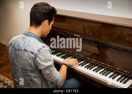 Beau mâle jeune artiste jouant son piano droit classique en bois, portrait Banque D'Images