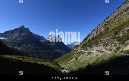 Un bus rouge jammer sur Aller à la route de Sun dans le Glacier National Park, Montana. Banque D'Images