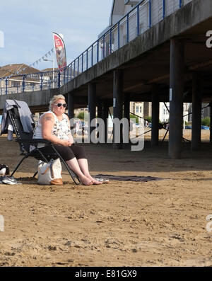 Femme mature dodue profiter du soleil sur la plage à l'ouest de London, 4 août 2014 Banque D'Images