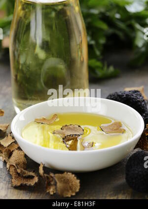 L'huile d'olive parfumée à la truffe noire sur une table en bois Banque D'Images