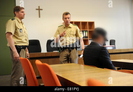 Munich, Allemagne. Sep 29, 2014. Le défendeur Rudolf K. est représenté dans une salle d'audience à la Cour régionale de Munich I à côté de deux agents de police à Munich, Allemagne, 29 septembre 2014. Le défendeur est accusé d'avoir poussé sa mère, qui souffrait d'un léger cas de démence, sous l'eau jusqu'à sa mort. PHOTO : TOBIAS HASE/DPA/Alamy Live News Banque D'Images