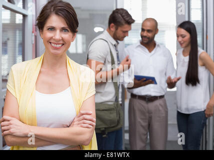 Smiling businesswoman posing with arms folded Banque D'Images