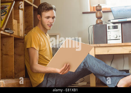 Jeune homme en regardant sa collection de vinyle Banque D'Images