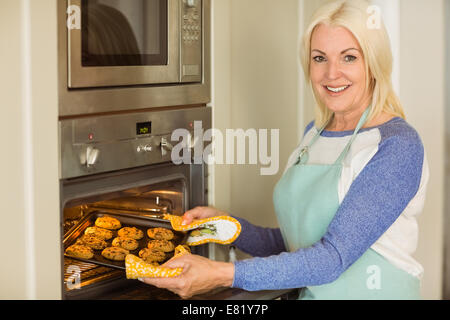 Femme tenant un plateau de biscuits frais hors du four Banque D'Images