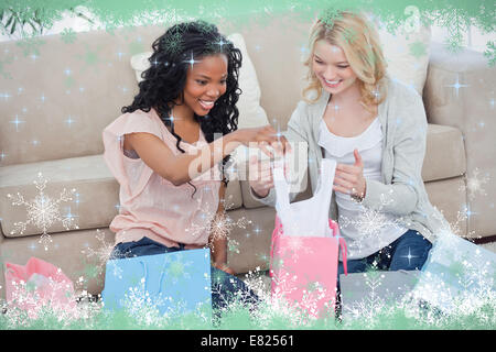 Deux femmes regarder à travers shopping bags Banque D'Images