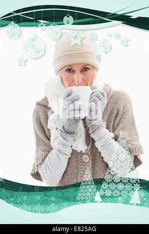 Composite image of woman in winter clothes holding mug Banque D'Images