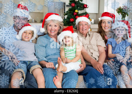 Image composite de famille à Santa hats celebrating christmas Banque D'Images