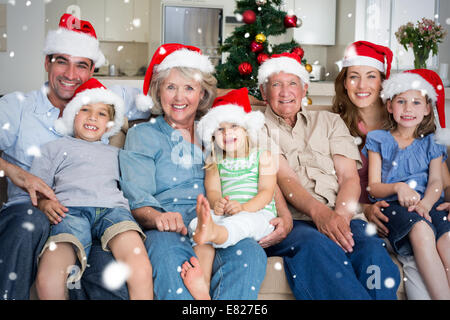 Image composite de famille à Santa hats celebrating christmas Banque D'Images