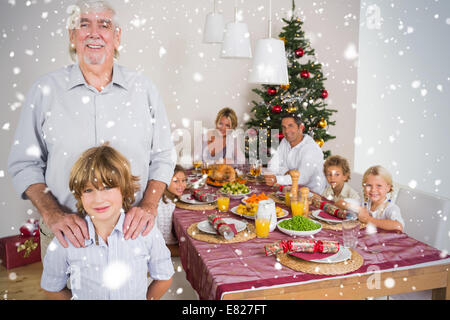 Image composite de grand-père et petit-fils debout à côté de la table de dîner Banque D'Images