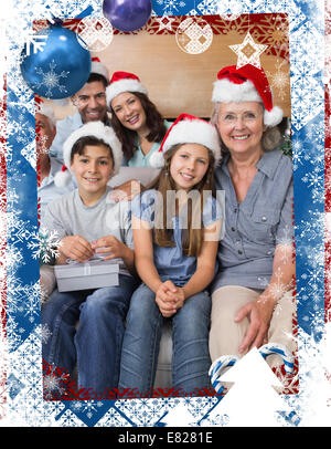 Famille étendue dans les chapeaux de Noël avec les coffrets cadeaux dans la salle de séjour Banque D'Images