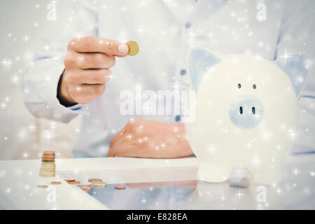 La partie centrale d'un homme de mettre quelques pièces dans une tirelire Banque D'Images