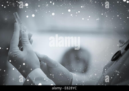 Image composite de doctor preparing a syringe Banque D'Images