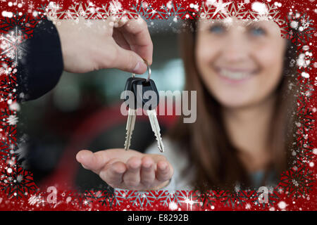 Composite image of woman smiling lors de la réception des clés de voiture Banque D'Images