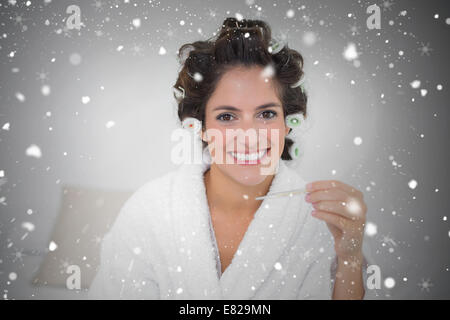 Composite image of natural brunette holding thermomètre Banque D'Images