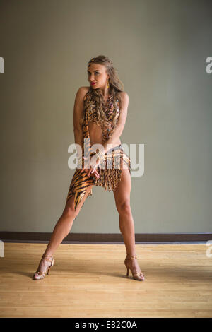 Danseur dans un studio de danse. Une femme avec une jambe tendus et a souligné toe. Banque D'Images