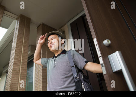 Un homme qui se tenait à sa porte avant. Banque D'Images