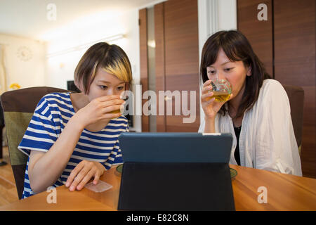 Deux femme assise à un ordinateur portable ou tablette numérique. Banque D'Images