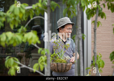 Un homme debout dans son jardin. Banque D'Images