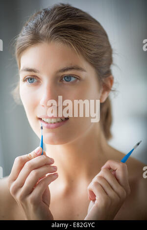 Femme à l'aide d'une brosse interdentaire. Banque D'Images