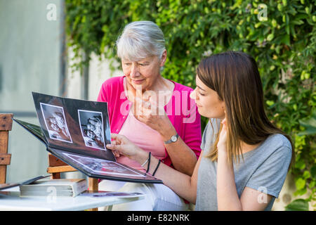 Les femmes à la recherche à l'album photo. Banque D'Images