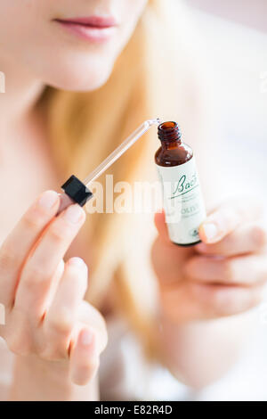 Femme à l'aide d'un remède de Bach (extrait de fleur de liquide). Banque D'Images