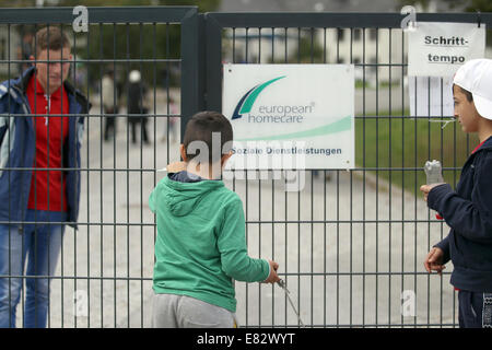 Burbach, Allemagne. Sep 29, 2014. Un garçon de ferme une porte de l'ancienne caserne de Siegerland Burbach, Allemagne, 29 septembre 2014. Des attaques violentes des réfugiés par des employés d'une compagnie de sécurité privée auraient eu lieu à un accueil des réfugiés dans la région de Burbach. Caserne Siegerland est actuellement utilisé comme hébergement d'urgence pour les demandeurs d'asile et réfugiés. Photo : INA FASSBENDER/DPA/Alamy Live News Banque D'Images
