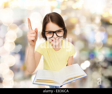 Smiling little girl à lunettes avec réserve Banque D'Images