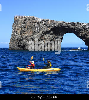 Les kayakistes raquette au-delà Arch Rock à Channel Islands National Park Banque D'Images