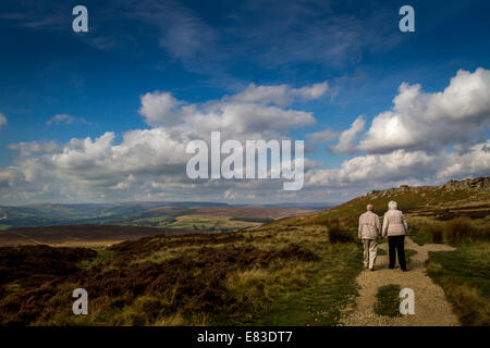 Les aînés vie : couple pour une promenade le long de Stanage Edge dans belle Derbyshire, Royaume-Uni Banque D'Images