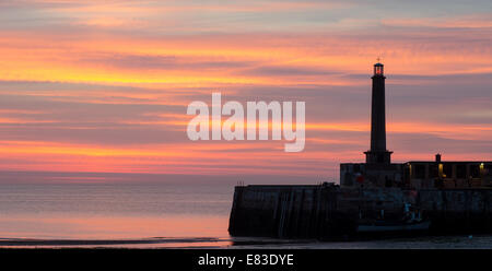 Beau coucher du soleil à Margate, Kent, Angleterre, montrant une partie de il mur du port et le phare Banque D'Images