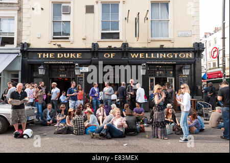 Les personnes qui boivent à l'extérieur du duc de Wellington pub sur Portobello Road, Notting Hill, London, England, UK Banque D'Images