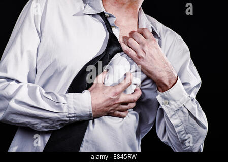 Homme Thumbs up avec un étroit part à son coeur et arrache sa chemise. Il a une crise cardiaque. Banque D'Images