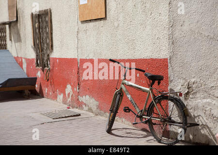 Une bicyclette repose contre un mur dans une rue latérale de Deira, Dubaï, Emirats Arabes Unis. Banque D'Images